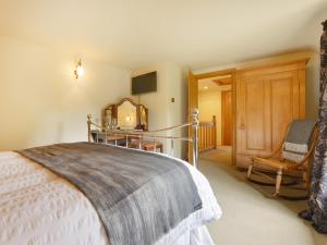 a bedroom with a bed and a chair at Pittards Farm Cottage in Lambrook
