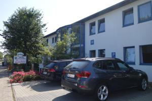 un par de autos estacionados frente a un edificio en Hotel Gästehaus Linden en Wolfenbüttel