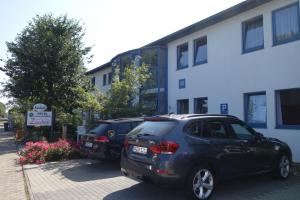 a couple of cars parked in front of a building at Hotel Gästehaus Linden in Wolfenbüttel