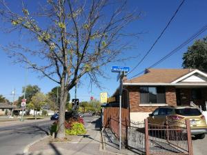 um sinal de rua em frente a uma casa com uma árvore em Cozy spacious Apt In Laval, Greater Montreal em Laval