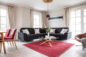 ein Wohnzimmer mit einem Sofa und einem Tisch in der Unterkunft Ferienhaus Seeadler 7 in Fuhlendorf