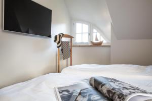 a bedroom with two beds and a flat screen tv at Ferienhaus Seeadler 65 in Fuhlendorf