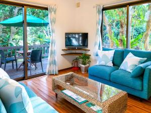 sala de estar con sofá azul y TV en Kachibai en Isla Ishigaki