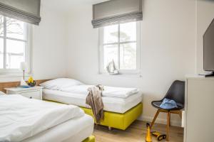 a bedroom with two beds and a chair at Ferienwohnung Duene 2_2 in Groß Kirr