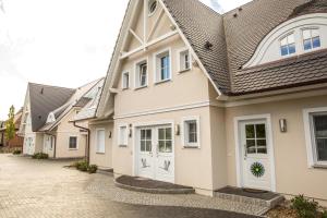 a house with white doors and a tile roof at Ferienwohnung Duene 2_2 in Groß Kirr