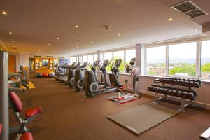 a gym with a row of treadmills and machines at Clayton Hotel Burlington Road in Dublin