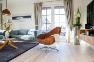 a living room with a couch and a chair at Ferienhaus Seeadler 3 in Fuhlendorf