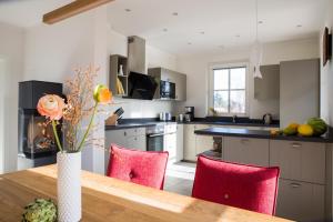 a kitchen with a wooden table and red chairs at Ferienhaus Seeadler 3 in Fuhlendorf