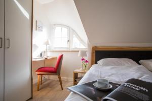 a bedroom with a bed and a chair and a table at Ferienhaus Seeadler 3 in Fuhlendorf