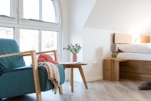 a bedroom with a bed and a table and a chair at Ferienhaus Schilfrohrsaenger 6 in Fuhlendorf