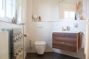 a bathroom with a toilet and a sink at Ferienhaus Schilfrohrsaenger 6 in Fuhlendorf +24 photos
