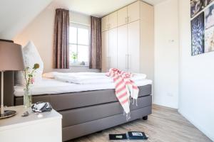 a bedroom with a bed with a scarf on it at Ferienhaus Schilfrohrsaenger 51 in Fuhlendorf