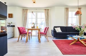 a living room with a table and chairs at Ferienhaus Seeadler 34 in Fuhlendorf