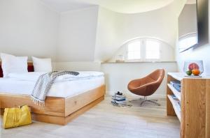 ein Schlafzimmer mit einem Bett und einem Stuhl in der Unterkunft Ferienhaus Seeadler 34 in Fuhlendorf