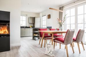 a kitchen with a table and chairs and a fireplace at Ferienhaus Seeadler 9 in Fuhlendorf