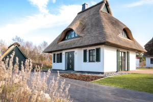 a thatched cottage with a grass roof at Ferienhaus Seeadler 9 in Fuhlendorf