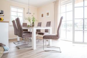 a dining room with a white table and chairs at Ferienhaus Haubenlerche 25 in Fuhlendorf