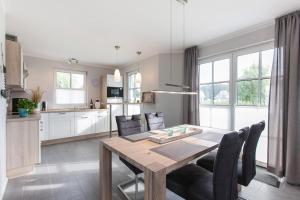 a kitchen and dining room with a table and chairs at Ferienhaus Seeschwalbe 37 in Fuhlendorf