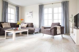 a living room with a couch and a chair and a table at Ferienhaus Seeadler 24 in Fuhlendorf