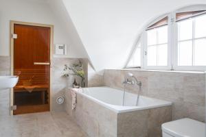 a bathroom with a bath tub and a sink at Ferienhaus Seeadler 24 in Fuhlendorf +23 photos