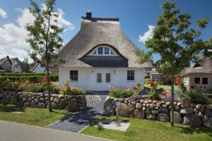 a cottage with a thatched roof at Ferienhaus Seeadler 24 in Fuhlendorf