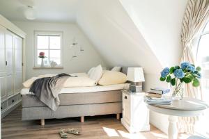 a bedroom with a bed with a table and a window at Ferienhaus Schilfrohrsaenger 61 in Fuhlendorf