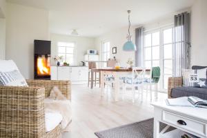 a living room with a couch and a dining room at Ferienhaus Seeschwalbe 44 in Fuhlendorf