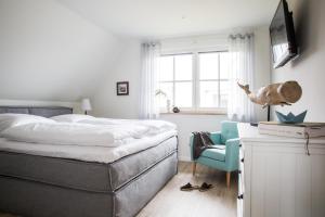 a bedroom with a bed and a blue chair at Ferienhaus Seeschwalbe 44 in Fuhlendorf