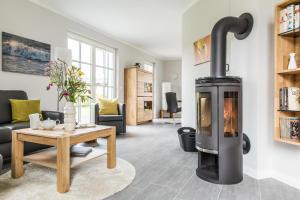 a living room with a wood burning stove at Ferienhaus Schilfrohrsaenger 36 in Fuhlendorf