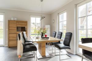 a dining room with a table and chairs at Ferienhaus Schilfrohrsaenger 36 in Fuhlendorf