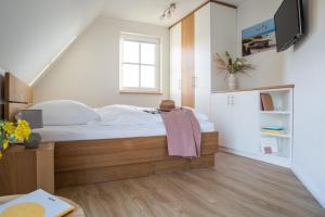 ein Schlafzimmer mit einem Bett und einem TV an der Wand in der Unterkunft Ferienhaus Schilfrohrsänger 8 in Fuhlendorf