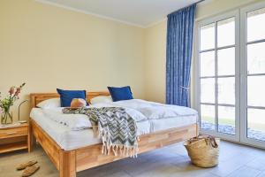 a bedroom with a wooden bed with blue curtains at Ferienhaus Graukranich 41 in Fuhlendorf