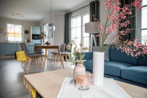 a living room with a blue couch and a table at Ferienhaus Seeschwalbe 33 in Fuhlendorf