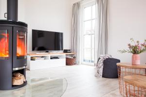 a living room with a fireplace and a tv at Ferienhaus Schilfrohrsaenger 45 in Fuhlendorf