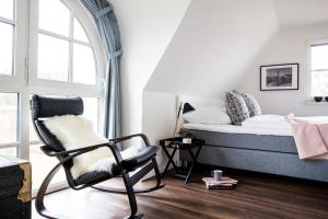 a bedroom with a bed and a chair and a window at Ferienhaus Schilfrohrsaenger 45 in Fuhlendorf