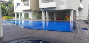 a large blue swimming pool in front of a building at Luxe Highway Residencies in Kottawa