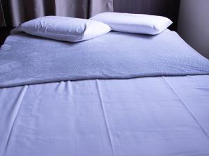 a white bed with two pillows on top of it at Paris Hotel by H Hotéis - Business in Taguatinga