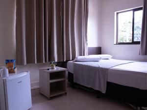 um pequeno quarto com uma cama e uma janela em Paris Hotel by H Hotéis - Business em Taguatinga