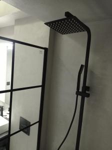 een badkamer met een spiegel en een lamp op de muur bij NY Central 1 in Patra