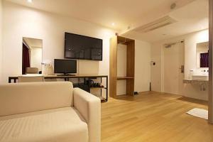 a living room with a couch and a flat screen tv at La Villa Hotel in Seoul