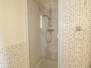 a bathroom with a shower with tiled walls at The Mouse House in Blandford Forum