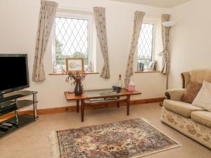 a living room with a couch and a tv at Foxhunter Cottage in Whitby