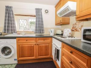 a kitchen with a washer and dryer at Foxhunter Cottage in Whitby