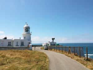 eine Straße, die zu einem Leuchtturm am Meer führt in der Unterkunft The Quillet in Penzance