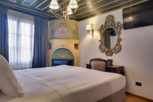 a bedroom with a large bed and a mirror at ARCHONTARIKI Historic Boutique Hotel in Ioannina