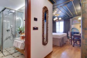 uma casa de banho com um espelho e um quarto com uma cama em ARCHONTARIKI Historic Boutique Hotel em Ioannina