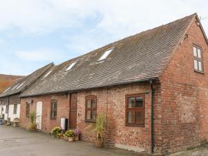 a brick building with windows and plants on it at Old Hall Barn 4 in Church Stretton