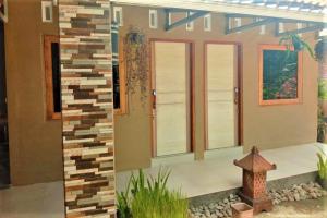 a rendering of a house with a stone wall at Penginapan Rudi Syariah in Bantul