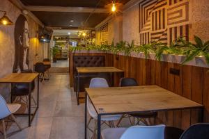 a restaurant with wooden tables and chairs and plants at Urbano Luxury Hotel in Pasto