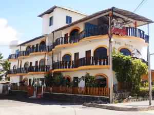 un edificio bianco con balconi su strada di Hostal Sandrita a Puerto Villamil